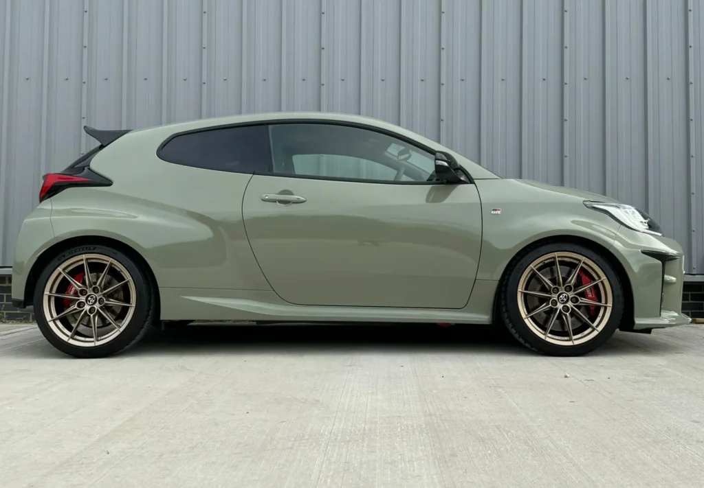 Small matte green car with gold alloys gleaming after ppf protection installation.