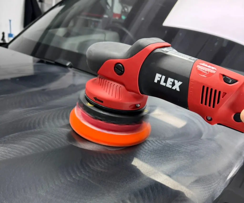 Car bonnet being buffed with buffing tool and paste.